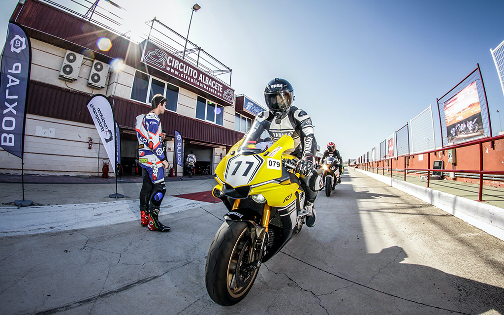 yellow motorcycle pulled into the racing track paddock