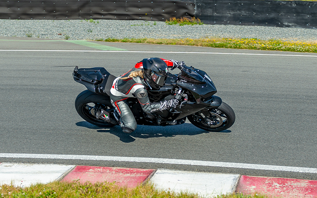 amber spencer cornering a black sports motorcycle on a track day