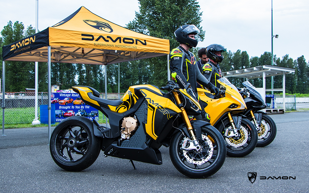 Jay and Broc standing next to damon hyperfighter, a gold damon hypersport, and a black damon hypersport